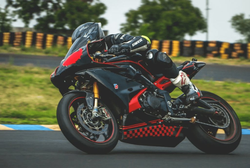 Atleta de motociclismo acelerando com intensidade em uma curva do circuito, totalmente concentrado e em sintonia com a moto. Uma demonstração de foco, técnica e coragem em alta velocidade.