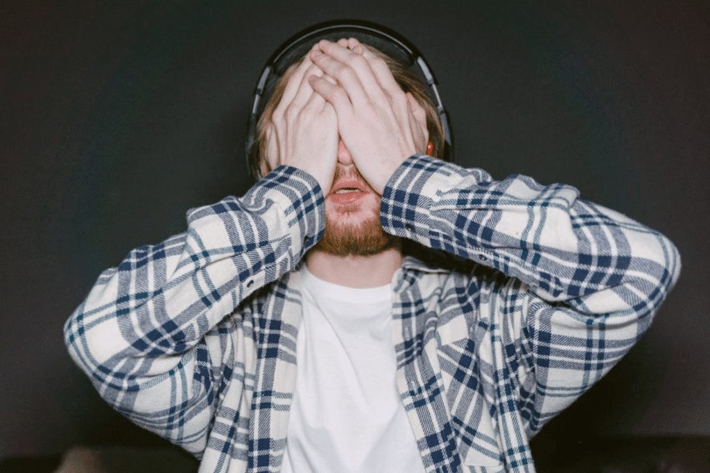 Jogador de eSports com a mão no rosto, demonstrando frustração após tomar uma decisão errada durante a partida. A cena retrata o impacto emocional das escolhas estratégicas no universo competitivo dos esportes eletrônicos, evidenciando o peso mental da performance.