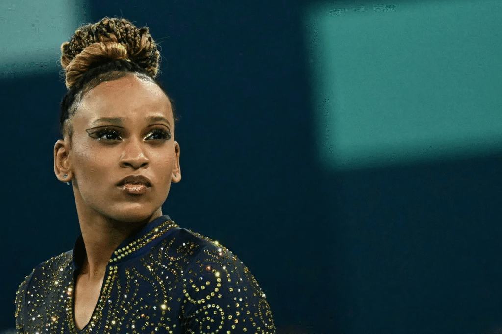 Rebeca Andrade com expressão concentrada e olhar determinado, maquiada e focada antes de iniciar mais uma apresentação na competição de ginástica artística em Paris 2024.